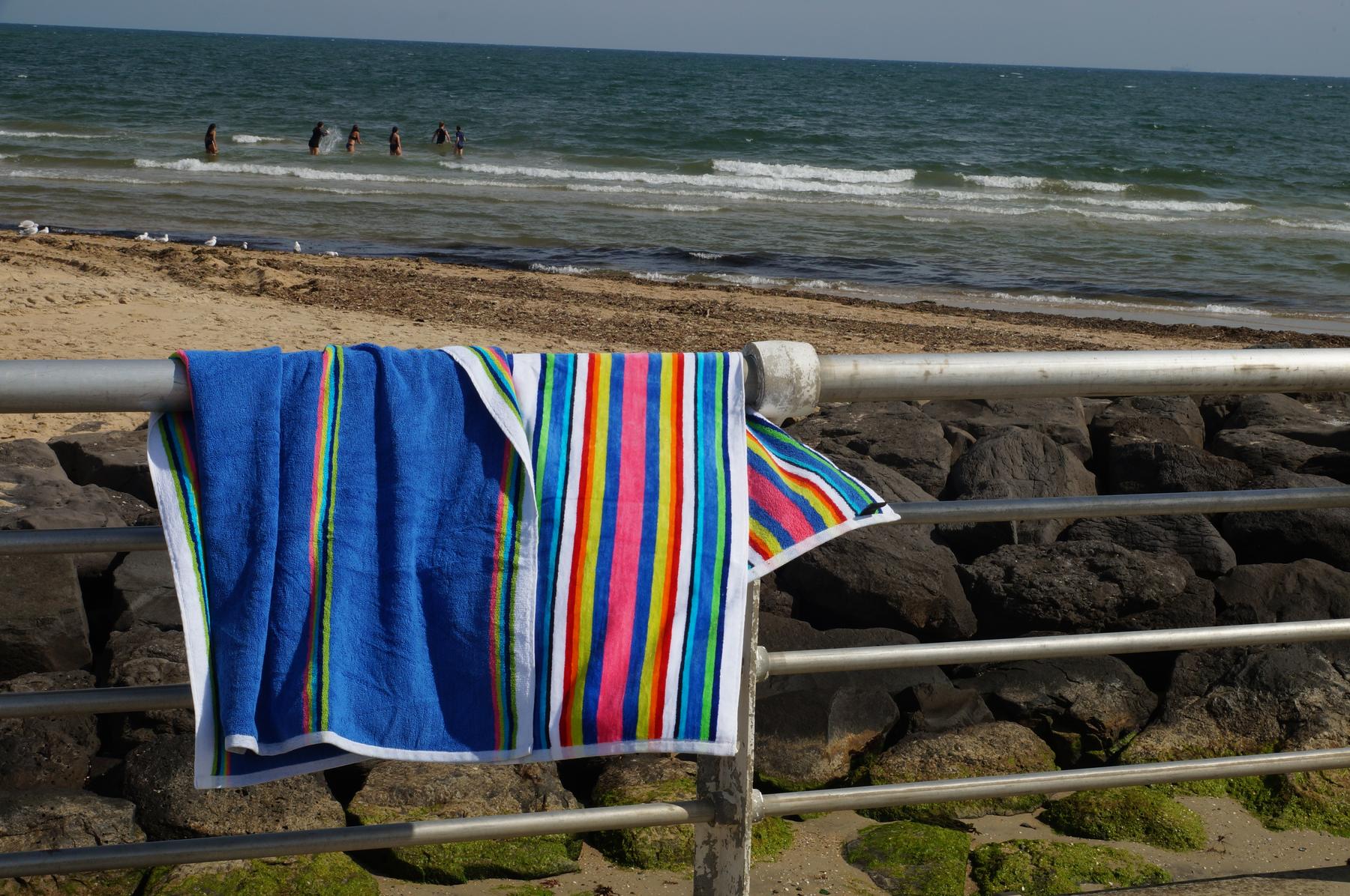 Striped cabana towels hung over the railing on the St Kilda foreshore in Melbourne