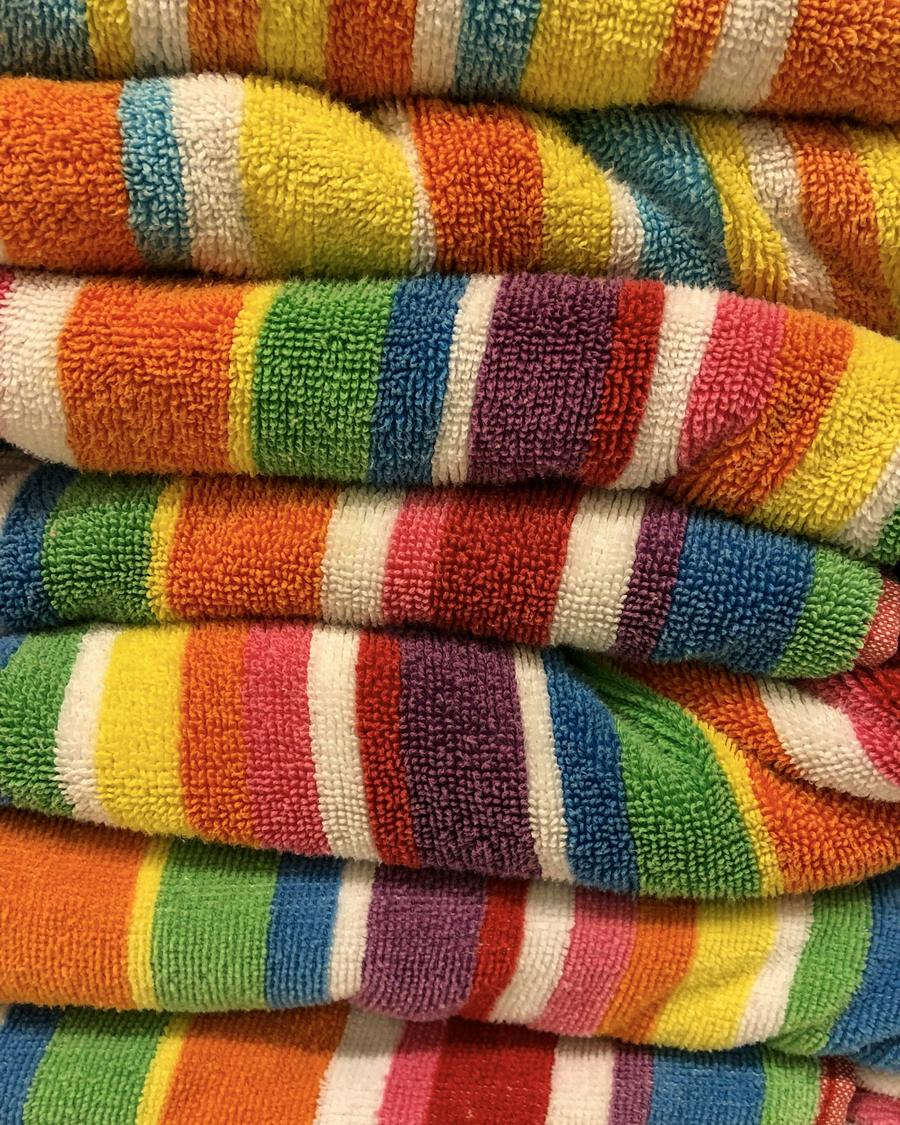 Stack of folded multi-coloured striped terry beach towels